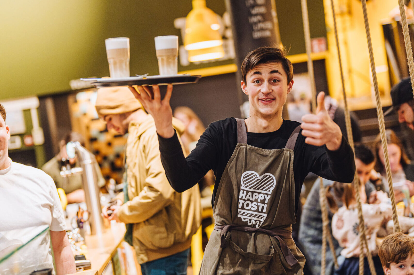 Julien (21) werkt via Social Capital bij Happy Tosti in Den Haag. Foto: Social Capital